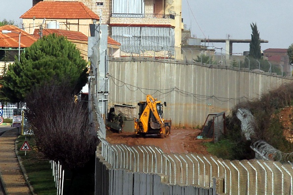 -Une photo prise le 9 décembre 2018 dans le village de Kfar Kila, dans le sud du Liban, près de la frontière israélienne, montre la machinerie israélienne opérant à proximité du mur en béton séparant les deux pays. L'armée israélienne a annoncé dimanche avoir localisé un autre tunnel traversant son territoire depuis le Liban. Photo ALI DIA / AFP / Getty Images.