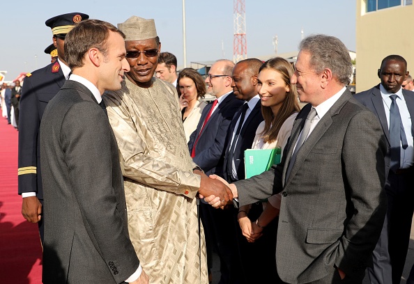 -Le président français Emmanuel Macron et le président tchadien Idriss Deby accueillent la star de la télévision française Michel Drucker préparant une émission sur les soldats du projet Barkhane à son arrivée à l'aéroport international de N'Djamena le 22 décembre 2018. Photo LUDOVIC MARIN / AFP / Getty Images.