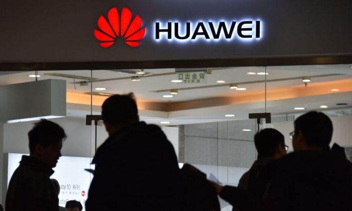 Des gens passent devant un magasin Huawei à Pékin le 10 décembre 2018. (Greg Baker/AFP/Getty Images)