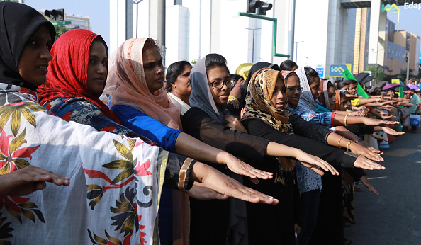 -Le 1 er janvier 2019, à Kochi, dans le sud de l'État du Kerala, des femmes indiennes tendent la main pour prendre part à une manifestation contre le « mur des femmes » à Köchi. Des dizaines de milliers de femmes ont formé une chaîne humaine, au soutien d'une ordonnance du tribunal annulant l'interdiction des femmes d'entrer dans l'un des temples les plus sacrés de l'hindouisme. Photo by - / AFP / Getty Images.