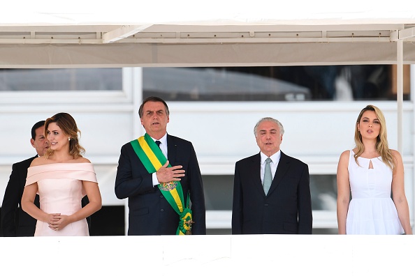 -La nouvelle Première dame du Brésil, Michelle Bolsonaro, le nouveau président du Brésil, Jair Bolsonaro, le président sortant du Brésil, Michel Temer, et son épouse, Marcela Temer, chantent l'hymne national après la remise de la ceinture présidentielle, au Palais Planalto de Brasilia, le 1er janvier 2019. Photo EVARISTO SA / AFP / Getty Images.