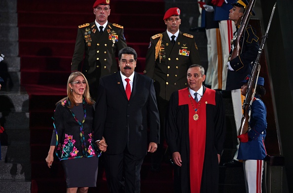 -Le président vénézuélien Nicolas Maduro s’installe aux côtés de la Première Dame Cilia Flores et du président de la Cour suprême de justice Maikel Moreno pour la cérémonie d’inauguration de son deuxième mandat, au siège du TSJ à Caracas le 10 janvier 2019. Maduro entame un nouveau mandat que les critiques qualifient d'illégitime, avec une économie en chute libre et un pays plus isolé que jamais. Photo YURI CORTEZ / AFP / Getty Images.