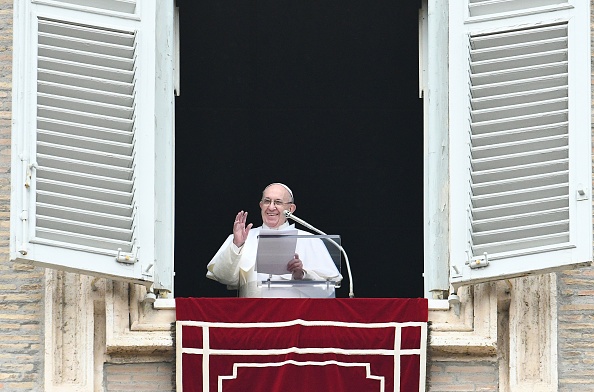 -Le pape François fait un signe de la main aux fidèles par la fenêtre du palais apostolique qui surplombe la place Saint-Pierre au Vatican, pour la prière hebdomadaire de l'Angélus le 20 janvier 2019. Photo de VINCENZO PINTO / AFP / Getty Images.