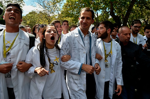 -Le chef de l'opposition et président autoproclamé, Juan Guaido marche entouré d'étudiants au cours d'une manifestation qu'il a convoquée contre le gouvernement du président Nicolas Maduro, le 30 janvier 2019. Le président vénézuélien, Nicolas Maduro, a attaqué mercredi des "mercenaires" de l'armée qui complotent pour diviser les forces armées et préparer un coup d'Etat alors que l'opposition organisait une nouvelle manifestation pour forcer le dirigeant socialiste à quitter le pouvoir. Photo de Luis ROBAYO / AFP / Getty Images.