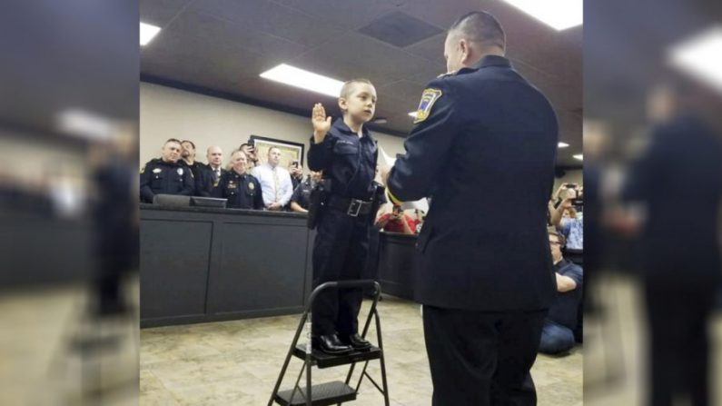 Sur cette photo du 7 février 2019 fournie par le service de police de Freeport, Abigail Arias, 6 ans, qui lutte contre le cancer, est assermentée comme agent de police du Texas par le chef de police de Freeport, Ray Garivey à Freeport, Texas. (Service de police de Freeport via AP)