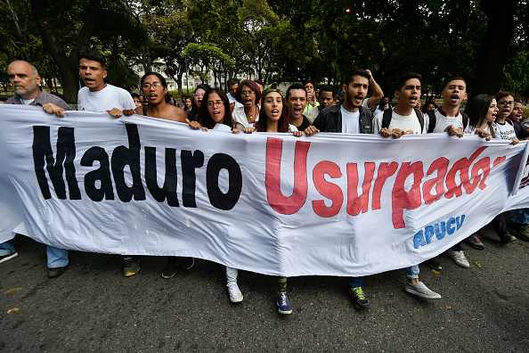 -Des étudiants de l'Université centrale du Venezuela à Caracas, tiennent une banderole portant l'inscription « Maduro usurper » lors d'une manifestation contre le gouvernement du président Nicolas Maduro, lancée le 30 janvier 2019 par le chef de l'opposition et président autoproclamé « président par intérim », Juan Guaido. Photo de Luis ROBAYO / AFP / Getty Images.