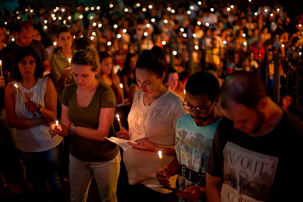 -Des gens prient devant l'église Brumadinho Matriz lors d'un service en l'honneur des personnes disparues et des victimes dans la communauté de Parque das Cachoeiras, après l'effondrement d'un barrage appartenant à la gigantesque société minière brésilienne Vale, le 25 janvier. Photo de Mauro Pimentel / AFP / Getty Images.