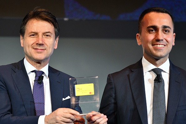 Le ministre italien du Travail et de l'Industrie, Luigi Di Maio (à droite) et le Premier ministre italien, Giuseppe Conte (à gauche), dévoilent la première carte "salaire de citoyenneté", le 4 février, 2019 à Rome. Le revenu de base est destiné aux familles et aux demandeurs d'emploi les plus démunis, qui se verront proposer trois emplois avant de perdre le droit au «salaire de citoyenneté». (Photo : ALBERTO PIZZOLI/AFP/Getty Images)