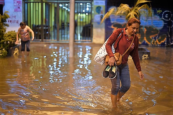 -Une femme marche pieds nus dans la rue inondée du quartier de Botafogo, après qu'une forte pluie ait inondé plusieurs zones de la ville de Rio de Janeiro, au Brésil, le 7 février 2019. Photo de Mauro Pimentel / AFP / Getty Images.