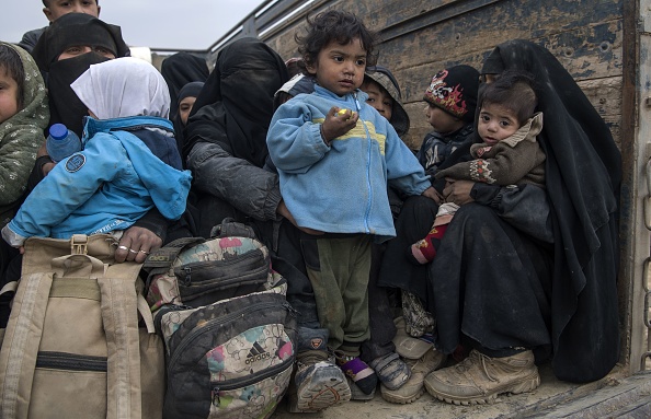 -Des femmes et des enfants qui ont fui le camp de Baghouz, prisonnier du groupe État islamique le 14 février 2019, attendent à l'arrière d'un camion dans la province syrienne de Deir Ezzor. Photo de Fadel SENNA / AFP / Getty Images.