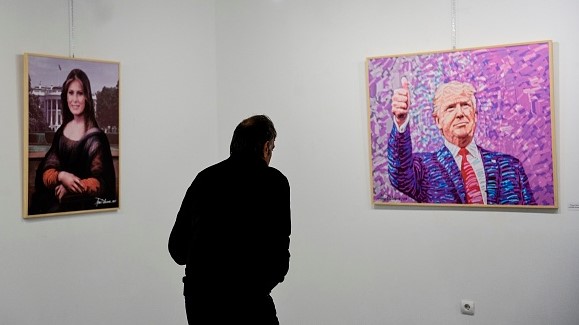 -Un visiteur découvre des peintures de l'artiste albanais Avni Delvina lors de l'exposition "The Donald" à Tirana le 19 février 2019. Donald Trump incarnant Rambo ou Jésus crucifié : un peintre a dédié cinquante peintures au président américain, son "idole", qui sont exposés dans la capitale albanaise. Photo de Gent SHKULLAKU / AFP / Getty Images.