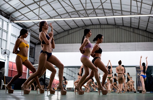 -Cette photo prise le 29 janvier 2019 montre des reines de beauté en herbe lors de la pratique de la « promenade des canards » dans un camp d'entraînement pour les beautés à Manille. Photo de Noel CELIS / AFP / Getty Images.