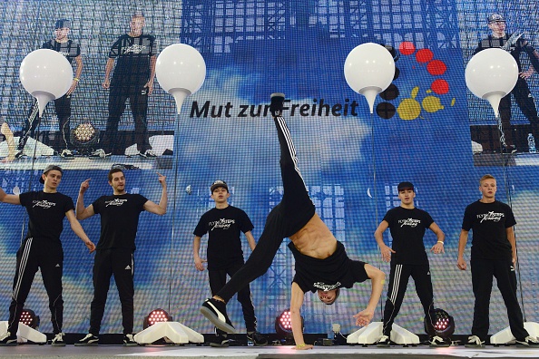 -Des danseurs de la Flying Steps Academy effectuent un break près de l'installation lumineuse Lichtgrenze sur une scène installée devant la porte de Brandebourg lors d'une fête de rue organisée par le gouvernement Allemand. Photo JOHN MACDOUGALL / AFP / Getty Images.