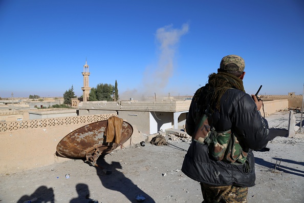 -Illustration. Un commandant de l'alliance kurde-arabe, connu sous le nom de Forces démocratiques syriennes, observe la mine exploser dans le lointain, depuis le toit d'un bâtiment du village de Tal Saman. Photo DELIL SOULEIMAN / AFP / Getty Images.