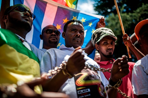 -Des membres du Forum de la diaspora africaine, des organisations de la société civile, des églises, des syndicats et d'autres coalitions portent des chaînes et crient des slogans lors d'une manifestation contre le trafic d'êtres humains en Libye le 12 décembre 2017. Photo GULSHAN KHAN / AFP / Getty Images.