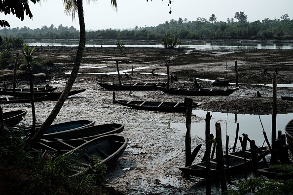 -Cette photo montre des bateaux de pêche tachés d'huile sur la boue huileuse de la rivière à marée basse dans le village de K-Dere, dans l'Ogoniland, près de Bodo, dans la région du delta du Niger, le 20 février 2019. Photo de Yasuyoshi CHIBA / AFP / Getty Images.