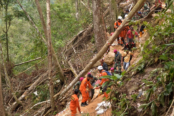 -Des membres d'une équipe de recherche et de sauvetage indonésienne transportent un survivant après l'effondrement d'une mine à Bolaang Mongondow, dans le nord de Sulawesi, le 28 février 2019. Photo UNGKE PEPOTOH / AFP / Getty Images.