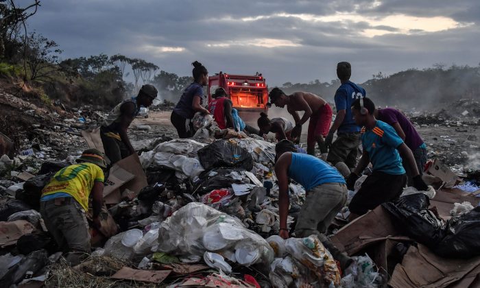 Les Vénézuéliens fouillent dans une décharge de la ville brésilienne de Pacaraima, à la frontière avec le Venezuela, le 28 février 2019. Vingt années de règne du régime socialiste ont détruit l’économie et provoqué une pénurie de produits de première nécessité au Venezuela. (NELSON ALMEIDA/AFP/Getty Images)