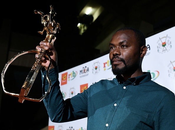 -Le réalisateur rwandais Joël Karekezi, lauréat du 26ème Festival panafricain du film et de la télévision (FESPACO) pour "La miséricorde de la jungle" pose avec le trophée Yennenga Stallion au Palais des sports de Ouagadougou le 2 mars 2019. Photo ISSOUF SANOGO / AFP / Getty Images.