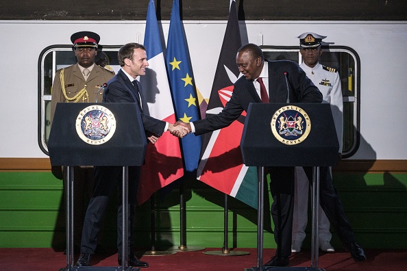 Le président Emmanuel Macron  serre la main du président kenyan Uhuru Kenyatta lors d'un événement à la gare centrale de Nairobi à Nairobi le 13 mars 2019, le premier jour d'une visite officielle au Kenya.    (Photo : YASUYOSHI CHIBA/AFP/Getty Images)