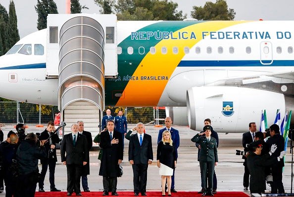 -Le Premier ministre israélien Benjamin Netanyahu et son épouse Sara accompagnés du président brésilien en visite Jair Bolsonaro écoutent les hymnes nationaux joués lors d'une cérémonie de bienvenue pour ce dernier à son arrivée à l'aéroport international de Tel Aviv Ben Gurion le 31 mars, 2019, pour sa première visite d'État en Israël. Photo de Jack GUEZ / AFP / Getty Images.