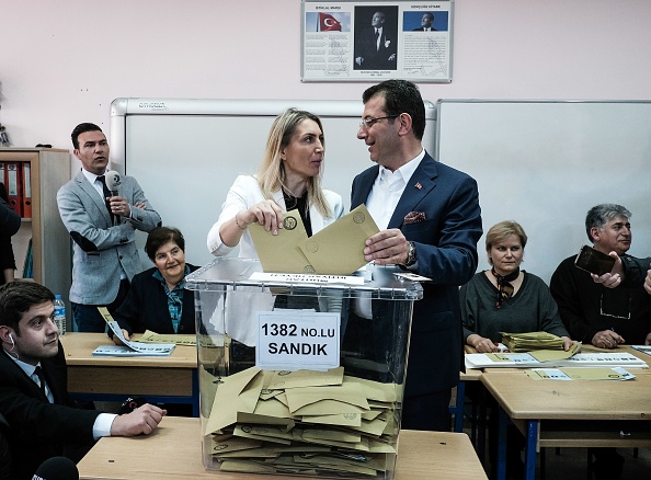 -Ekrem Imamoglu, candidat au maire du Parti turc du principal parti d'opposition turc, et son épouse, posent devant le bureau de vote d'Istanbul le 31 mars 2019. Photo de Yasin AKGUL / AFP / Getty Images.