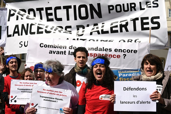 -Des manifestants brandissent des pancartes indiquant « Levez-vous pour les dénonciateurs », le 26 avril 2016, devant le tribunal de Luxembourg, à l'appui du dénonciateur Antoine Deltour, lors de son procès pour le prétendu scandale LuxLeaks qui a révélé les énormes allègements fiscaux dont bénéficient les grandes entreprises internationales dans le pays. Photo JOHN THYS/AFP/Getty Images.