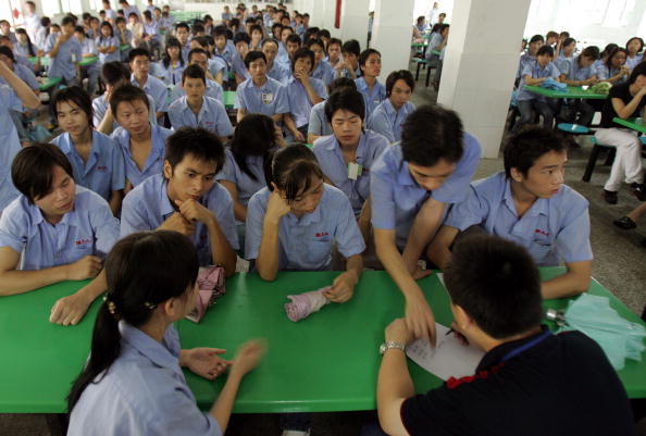 -Des travailleurs ont bloqué une route pour protester contre la réduction de leur salaire par l'employeur. Les autorités s'inquiètent des plaintes des personnes à faible revenu face à la hausse de l'inflation. Photo par China Photos / Getty Images.