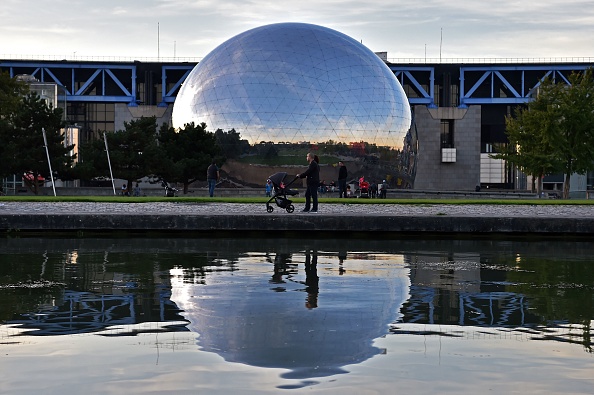 -Les gens marchent le long du canal de l'Ourcq devant le dôme de la Géode à la Cité des sciences et de l'industrie du parc de la Villette à Paris le 4 octobre 2017. Photo CHRISTOPHE ARCHAMBAULT / AFP / Getty Images.