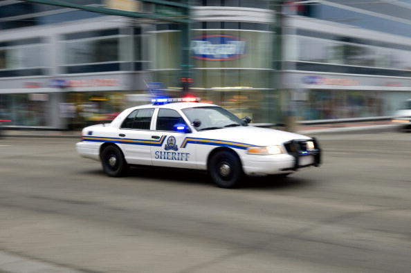 -Illustration-Une voiture du shérif fonce dans les rues du centre-ville en route vers une prise d’otage. Photo de Dylan Lynch / Getty Images.