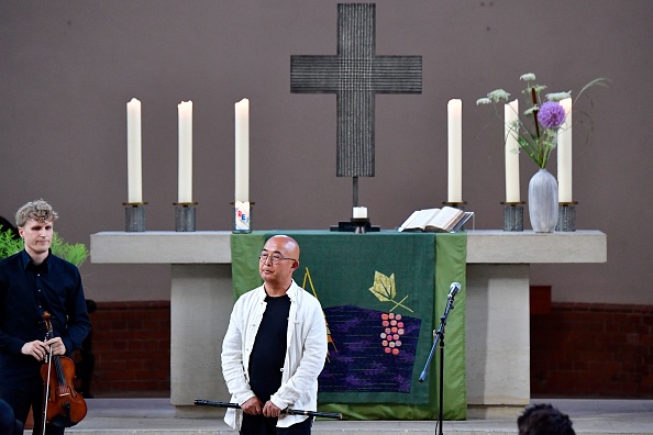 -L'écrivain exilé chinois Liao Yiwu tient une flûte après avoir participé à une commémoration du regretté dissident chinois et lauréat du prix Nobel de la paix, Liu Xiaobo, à Berlin le 13 juillet 2018. Photo de Tobias SCHWARZ / AFP Getty Images.