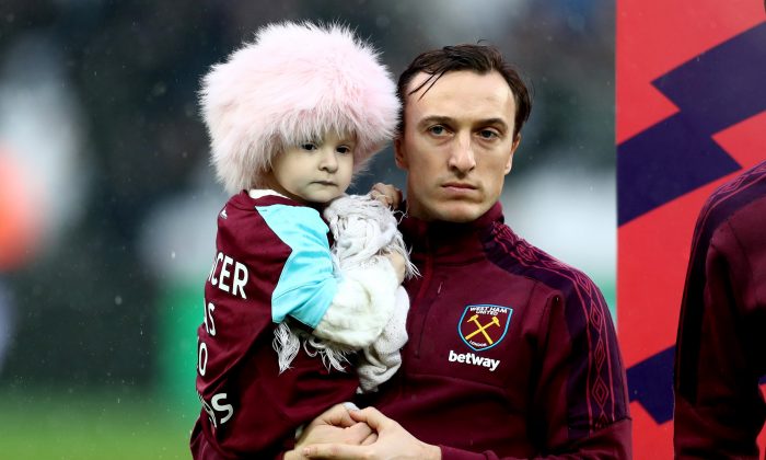 Mark Noble, de West Ham United, tient Isla Caton dans ses bras avant le match de Premier League entre West Ham United et l'AFC Bournemouth au London Stadium de Londres, Royaume-Uni, le 20 janvier 2018. (Catherine Ivill/Getty Images)
