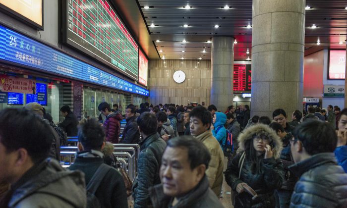 Les voyageurs chinois font la queue à la gare de Pékin pour acheter des billets de train et pouvoir se réunir en famille lors du Nouvel An chinois, le 4 février 2015. Selon le rapport du régime chinois sur les sanctions infligées dans le cadre du système de « crédit social », en 2018, les voyageurs chinois n’ont pas pu acheter un billet d’avion 17,5 millions de fois en guise de pénalité pour non-paiement d'amendes ou autres infractions. (Fred Dufour/AFP/Getty Images)