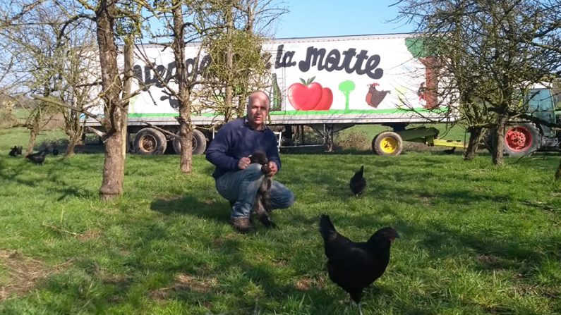 Christophe Bitauld dans son verger, avec un agneau dans les bras et des poules noires de Janzé : le triptyque gagnant qui lui permet d'obtenir des résultats exceptionnels - Crédit : Christophe Bitauld