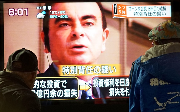 -Cette photo prise le 21 décembre 2018 montre des piétons en train de regarder un programme d'informations télévisé mettant en vedette l'ancien chef de Nissan, Carlos Ghosn, à Tokyo. Photo de Kazuhiro NOGI / AFP / Getty Images.