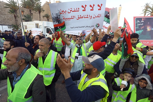 -Un libyen porte une pancarte appelant à la fin des combats lors d'une manifestation contre l'homme fort Khalifa Haftar sur la place des Martyrs, dans la capitale, à Tripoli, le 19 avril 2019. Photo de Mahmud TURKIA / AFP /Getty Images.