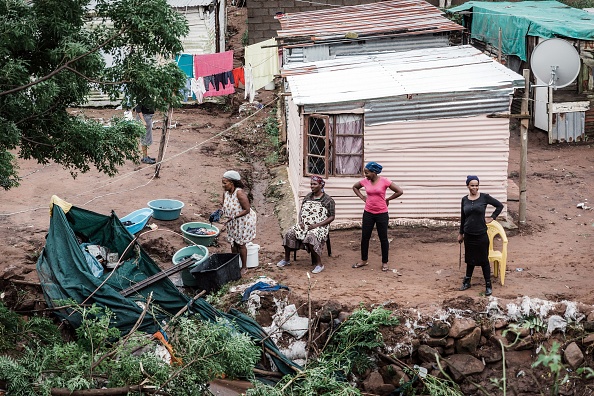 -Les femmes commencent à reconstruire leurs maisons après avoir été détruites par les pluies torrentielles et les inondations soudaines qui ont détruit des maisons dans un campement informel au sud de Durban, le 23 avril 2019. Photo RAJESH JANTILAL / AFP / Getty Images.