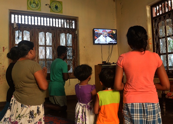 -Une famille catholique prie chez elle près de l'église Saint-Sébastien à Negombo elle suit un programme télévisé animé le 28 avril 2019 par l'archevêque de Colombo, le cardinal Malcolm Ranjith. Le pays a été marqué depuis que des kamikazes ont frappé trois églises et trois hôtels de luxe. Photo ISHARA S. KODIKARA / AFP / Getty Images.