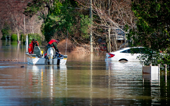 -La police canadienne passe à côté d'une voiture partiellement submergée dans l'eau sur une rue inondée à Sainte-Marthe-sur-le-Lac, dans la banlieue de Montréal, Québec, Canada, le 28 avril 2019. Photo de Sébastien St-Jean / AFP / Getty Images.