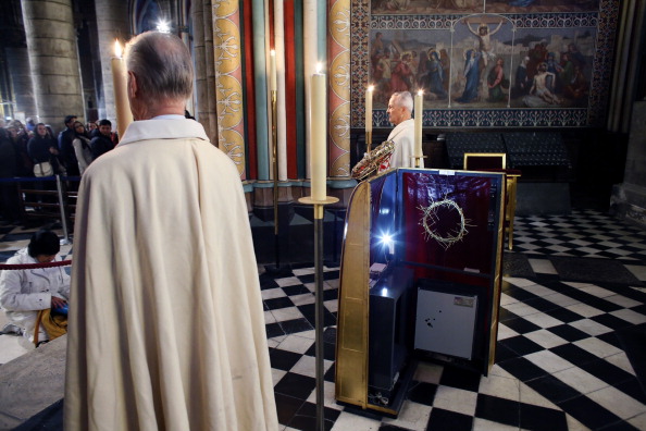 -Les chevaliers de l'ordre du Saint-Sépulcre déposent la couronne d'épines, l'un des instruments de la Passion de Jésus, sur une vitrine lors de la remise de la relique aux fidèles à la cathédrale Notre-Dame de Paris, le 7 décembre 2012 à Paris. Chef-d'œuvre de l'art gothique, la cathédrale Notre-Dame de Paris a fêté ses 850 ans le 12 décembre 2012. Photo PATRICK KOVARIK / AFP / Getty Images.