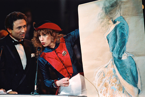 -L'actrice française Anémone commente son portrait après avoir reçu à Paris une statue de César du présentateur de télévision française Michel Drucker le 12 mars 1988 à Paris lors de la 13ème Académie française César Awards. Photo PIERRE VERDY / AFP / Getty Images.