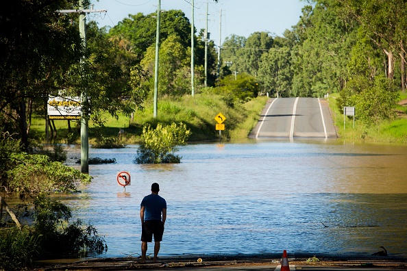 -Un résident observe une route submergée par les eaux du cyclone à North MacLean, Brisbane. Des rivières inondées se soulevaient toujours le 1er avril dans deux États australiens, des pluies diluviennes à la suite d’un puissant cyclone tropical. Photo d’illustration PATRICK HAMILTON / AFP / Getty Images.