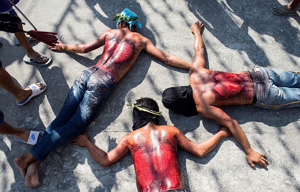 -Les participants sont couchés sur le sol après avoir été fouetté dans le dos lors de la reconstitution de la cérémonie de la crucifixion de Jésus-Christ pour les célébrations du vendredi Saint en prévision de Pâques dans le village de San Juan, à Pampanga, au nord de Manille. Photo NOEL CELIS / AFP / Getty Images.