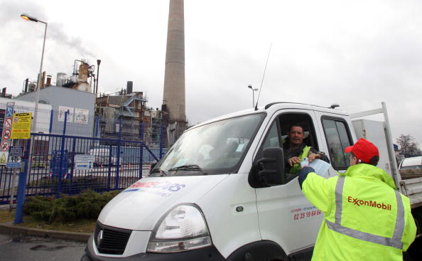 -Un travailleur du syndicat français CGT distribue des tracts devant la raffinerie américaine ExxonMobil à Port-Jérôme, dans l'ouest de la France. Le syndicat français CGT a appelé les travailleurs d'Exxon mobil à se joindre à la grève de six jours du géant français Total Workers qui ont cherché à étouffer l’approvisionnement en carburant pour forcer Total à garantir leurs emplois. Photo KENZO TRIBOUILLARD / AFP / Getty Images.