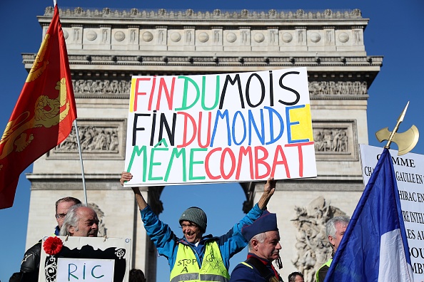 À Paris, un manifestant brandit une pancarte de sa confection pendant l’acte 15 des Gilets jaunes, le 23 février 2019, afin de réclamer davantage de pouvoir d’achat. Photo d’illustration. Crédit : ZAKARIA ABDELKAFI/AFP/Getty Images.