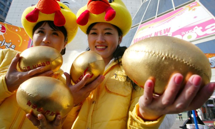 Des femmes tenant des œufs d'or artificiels et farcis. (Chung Sung-Jun/Getty Images)