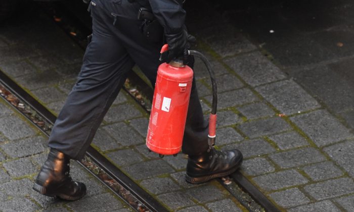 Un policier portant un extincteur. (Images impaires d'Andersen/AFP/Getty)