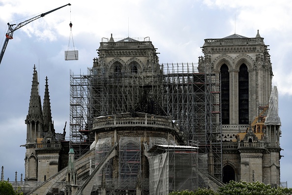 Une grue soulève un panneau dans le cadre des travaux de reconstruction de la cathédrale Notre Dame de Paris le 26 avril 2019, après que le monument ait été gravement endommagé par un énorme incendie le 15 avril dernier. (Photo : BERTRAND GUAY/AFP/Getty Images) 