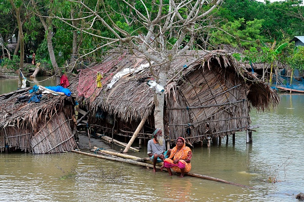 -Le 4 mai 2019, à Khulna, un couple de personnes âgées en détresse assis sur une bûche près de chez eux, entourée de hautes eaux, lorsque le cyclone Fani a atteint le Bangladesh. Photo de MUNIR UZ ZAMAN / AFP / Getty Images.