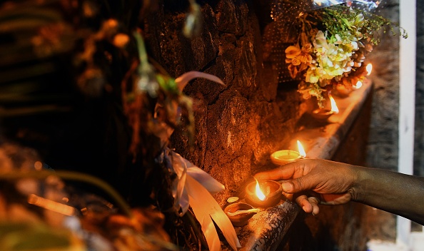 -Une personne allume des lampes à l'huile de coco pour les victimes des attentats à la bombe du dimanche de Pâques à l'église de Saint-Sébastien à Negombo, près de Colombo, le 4 mai 2019. L'église catholique de Sri Lanka a annulé son projet de reprise des services le dimanche à la suite d'une "menace spécifique" contre deux lieux de culte après les attaques du dimanche de Pâques. Photo par ISHARA S. KODIKARA / AFP / Getty Images.